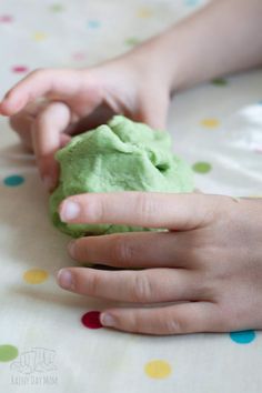 a child is playing with green play dough