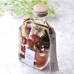 a bottle filled with lots of flowers sitting on top of a table