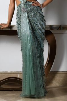 Sea green and blue sleeveless draped gown with all over astral bloom embroidery using tonal crystals, beads, sequins, pearls, cutdana highlights, side cutout, criss cross back and cutwork borders detail. - Aza Fashions Embellished Saree Dress For Gala, Embellished Draped Gown For Reception, Sleeveless Green Gown For Reception, Green Hand Embellished Gown For Reception, Green Sequined Reception Gown, Green Sequined Gown For Reception, Green Draped Gown For Party, Green Embellished Pre-draped Saree For Reception, Embellished Green Pre-draped Saree For Reception