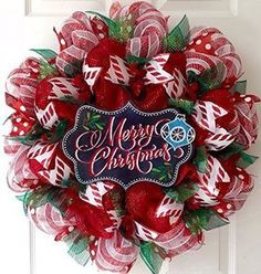 a christmas wreath on the front door with merry lettering and candy canes attached to it