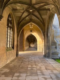 an arched hallway with stone flooring and arches on both sides, leading into the distance