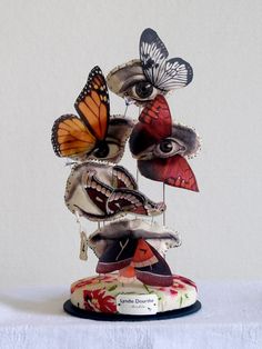 three butterflies on top of each other and one has its eyes opened to look at the viewer