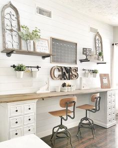 a desk with two chairs and some plants on it