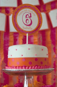 a birthday cake with pink and orange decorations