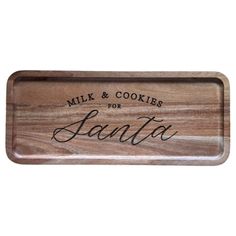 a wooden tray with the words milk and cookies for santa written in cursive writing