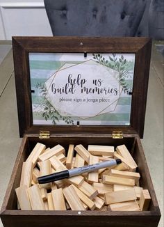 a wooden box filled with lots of wood blocks and a pen in the top one