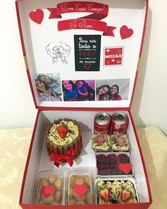 an open box filled with different types of cakes and desserts on top of a table