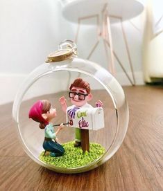 a glass ornament with a girl and boy in it