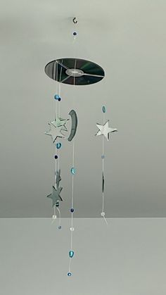 a mobile with stars, moon and crescent hanging from the ceiling in a gray room