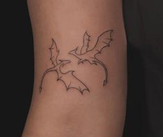 a small bat tattoo on the right side of the leg, it is black and white