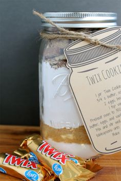 a jar filled with cookies next to two candy bars