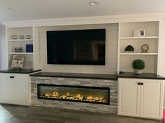 an entertainment center with built - in fireplace and flat screen tv mounted on the wall