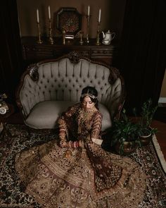 a woman sitting on top of a rug in front of a couch