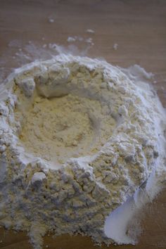 a bowl filled with white powder on top of a wooden table