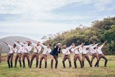 a group of men standing next to each other on top of a lush green field