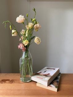 a vase with flowers on a table next to a book