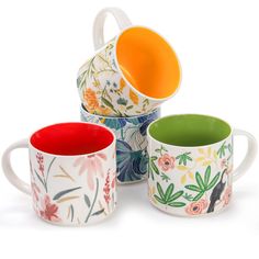 four mugs with different designs on them sitting next to each other in front of a white background