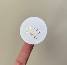 a person's finger is holding up a white sticker with the word ad on it