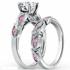 two wedding rings with pink and white diamonds