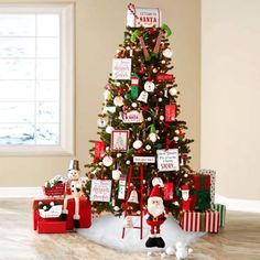 a decorated christmas tree in the corner of a living room with presents and santa clause decorations