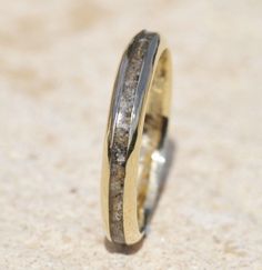 a wedding ring with gold and silver inlays on the inside, sitting on a beige surface