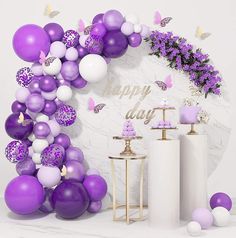 purple and white balloons are on display in front of a marble wall with butterflies, flowers and