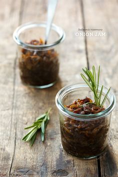 two jars filled with food sitting on top of a wooden table