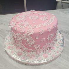 a pink cake with white flowers on it