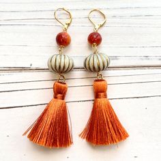 Pumpkin earrings to fall in love. Lightweight fall earrings with silky burnt orange tassels, apple coral beads and gilded pumpkins. Gold-plated, nickel-free lever backs. 3.5" drop. Orange Bohemian Earrings For Festive Occasions, Bohemian Orange Tassel Earrings, Orange Tassel Drop Earrings, Orange Tassel Drop Earrings As Gift, Orange Tassel Drop Earrings For Gift, Adjustable Orange Tassel Earrings, Elegant Orange Tassel Earrings For Gift, Orange Tassel Dangle Earrings, Orange Tassel Earrings Gift