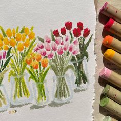 some crayons are next to some flowers in vases on a piece of paper