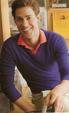 a man sitting at a table with food in front of him and smiling for the camera