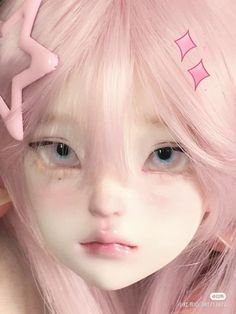 a close up of a doll with pink hair and stars on it's forehead