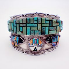 "Native American Zuni handmade massive sterling silver cuff bracelet, decorated with spectacular Turquoise maze, applied silver leaves or feathers as well as tribal Sun Face and bear figures, made of multi-colored inlaid gemstones. Borders are accented with embossed patterns and applied twisted wire rims. This incredible bracelet is 6 5/8\" long, 2 3/8\" at the widest and weighs 128.2 grams. EA2473" Multicolor Handmade Cuff Bracelet Collectible, Handmade Multicolor Cuff Bracelet Collectible, Artisan Multicolor Cuff Bracelet With Inlay, Artisan Multicolor Inlay Cuff Bracelet, Turquoise Inlay Bracelet For Collectors, Southwestern Multicolor Bracelets With Inlay, Artisan Multicolor Bracelets With Inlay, Multicolor Artisan Bracelet With Inlay, Multicolor Artisan Inlay Bracelets