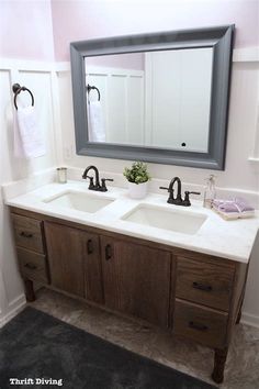 a bathroom vanity with two sinks and a large mirror above it, along with towels hanging on the wall