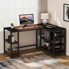 a desk with a computer on top of it in front of a window and rug