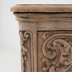 an old wooden cabinet with carved designs on it's doors and drawer fronts, against a white background