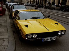 a yellow car is parked on the side of the street