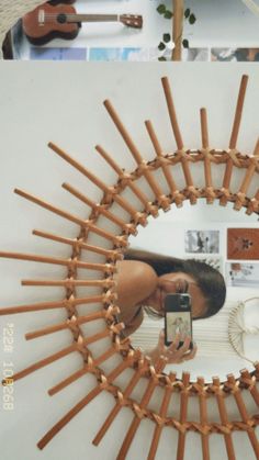 a woman taking a selfie with her cell phone in front of a mirror made out of sticks