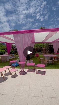 a pink and white tent sitting on top of a lush green field