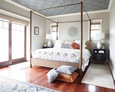 a bedroom with a four poster bed and wooden floors