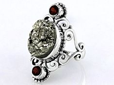 Artisan Collection of India™  12.98ct Oval Pyrite & 0.40ctw Round Garnet Sterling Silver Ring. Measures Approximately 0.81"L x 1.24"W. Not Sizeable. Polished Silver Gemstones For Anniversary, Silver Gemstones With Polished Finish For Anniversary, Polished Silver Gemstones For Wedding, Wedding Silver Polished Gemstones, Fusion Oval Jewelry With Accent Stones, Fusion Style Gemstone Accents Jewelry For Anniversary, Fusion Style Jewelry With Gemstone Accents For Anniversary, Luxury Silver Gemstones For Anniversary, Fusion Style Round Gemstones With Accent Stones