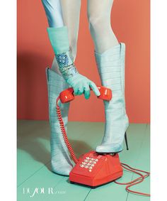 a woman's legs and boots are shown with an old fashioned telephone