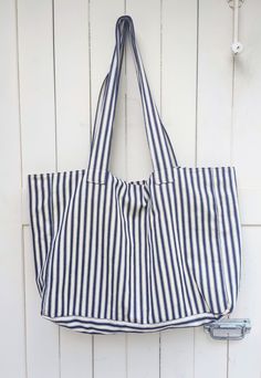 "These gorgeous totes are the perfect accessory for the summer. Handmade from blue ticking stripe cotton. Perfect for the market or for the beach. Sturdy and roomy, they can fit just about everything. The interior is fully lined with coordinating 100% cotton, and includes an interior pocket and a magnetic clasp closure.  Bag measures: 48cm (19\") wide 36cm (14\") tall 14cm (5.5\") deep Handle has a 38cm (15\") drop   Made in a smoke- and pet-free environment." Cotton Beach Bag, French Stripes, Market Bags, Striped Towels, Patchwork Bags, Ticking Stripe, Beach Bags, Market Bag, Magnetic Clasp