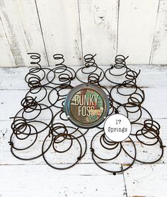 a bunch of metal rings sitting on top of a white wooden floor next to a sign