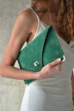 The perfect bag for all day needs, evening entertainment and going to a party.This adorable bag is handmade out of a beautiful high quality, emerald green suede Italian leather.It is hand stitched with green waxed thread. The color of the waxed thread can change upon request.The interior is fully lined with beige leatherette.The clutch closes with a metal twisted clasp and has metal endings, available in silver and gold color. The pictures show the clutch with gold metal hardware.Dimensions: Hei Luxury Green Clutch With Detachable Strap, Chic Green Pouch Evening Bag, Chic Green Clutch Evening Bag, Soft Leather Rectangular Clutch For Party, Chic Green Leather Clutch, Green Envelope Clutch For Everyday Use, Handmade Leather Evening Clutch, Chic Green Envelope Bag, Elegant Green Envelope Clutch