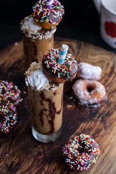 iced coffee with sprinkles and doughnuts on the side, sitting on a wooden table