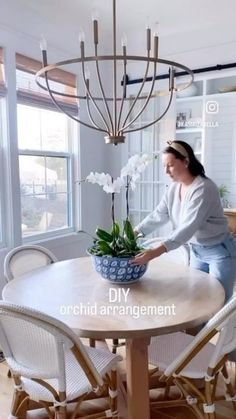 a woman sitting at a table with a potted plant