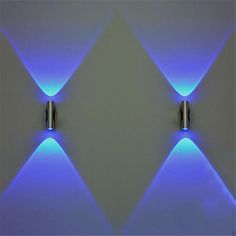 two blue lights that are next to each other on a white wall in a room