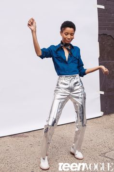 a woman in silver pants and blue shirt dancing