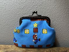 a blue purse with mario on it sitting on top of a wooden table next to a wall